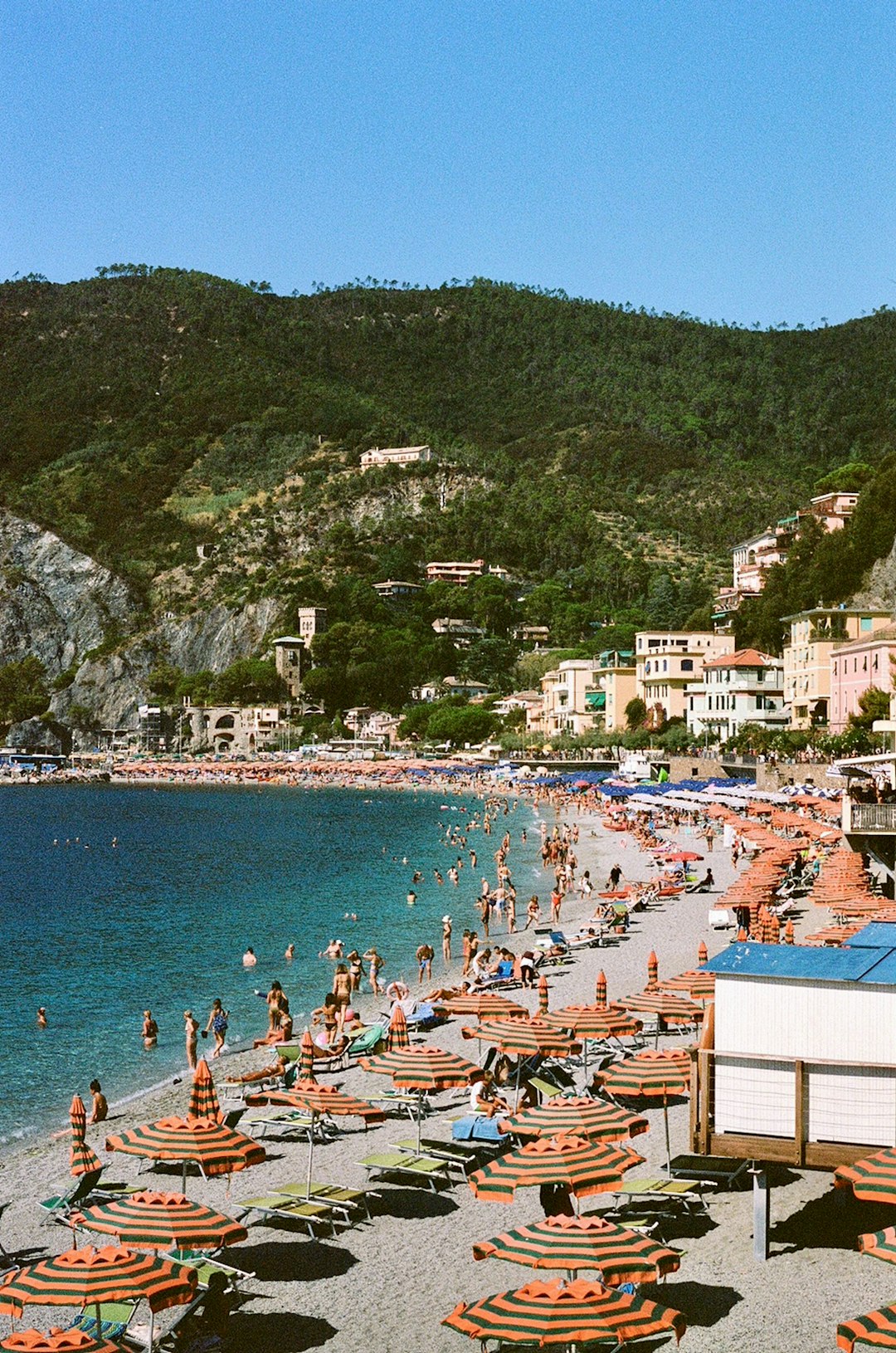 Italian summer beach holiday scene crowded with sunbathers and umbrellas in August